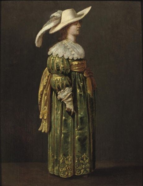an-elegant-woman-full-length-standing-in-profile-in-a-green-and-gold-embroidered-dress-and-feathered-hat