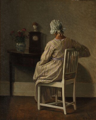 interior-with-a-woman-seated-at-a-console-table-her-back-turned-to-the-viewer